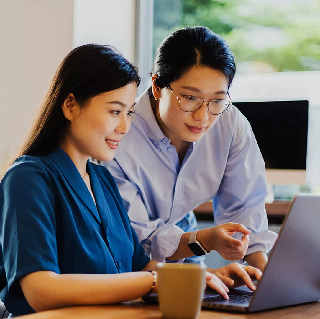 Two colleagues working together on a laptop